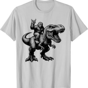 Bigfoot Riding T-Rex T-Shirt featuring Sasquatch riding a roaring Tyrannosaurus rex in a vintage-inspired graphic design.